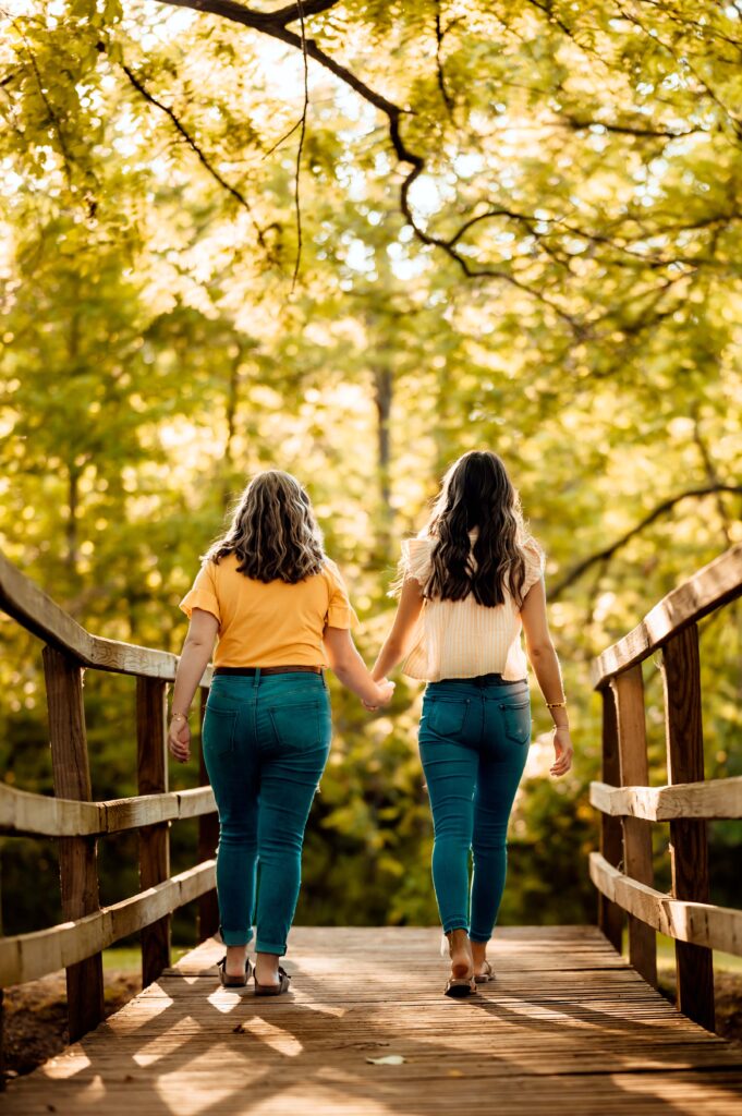 JMR_0718-Edit | Two Wild Souls Photography Two Oxford High School seniors walking hand in hand across the footbridge at Van Hoosen Farm in Rochester, Michigan