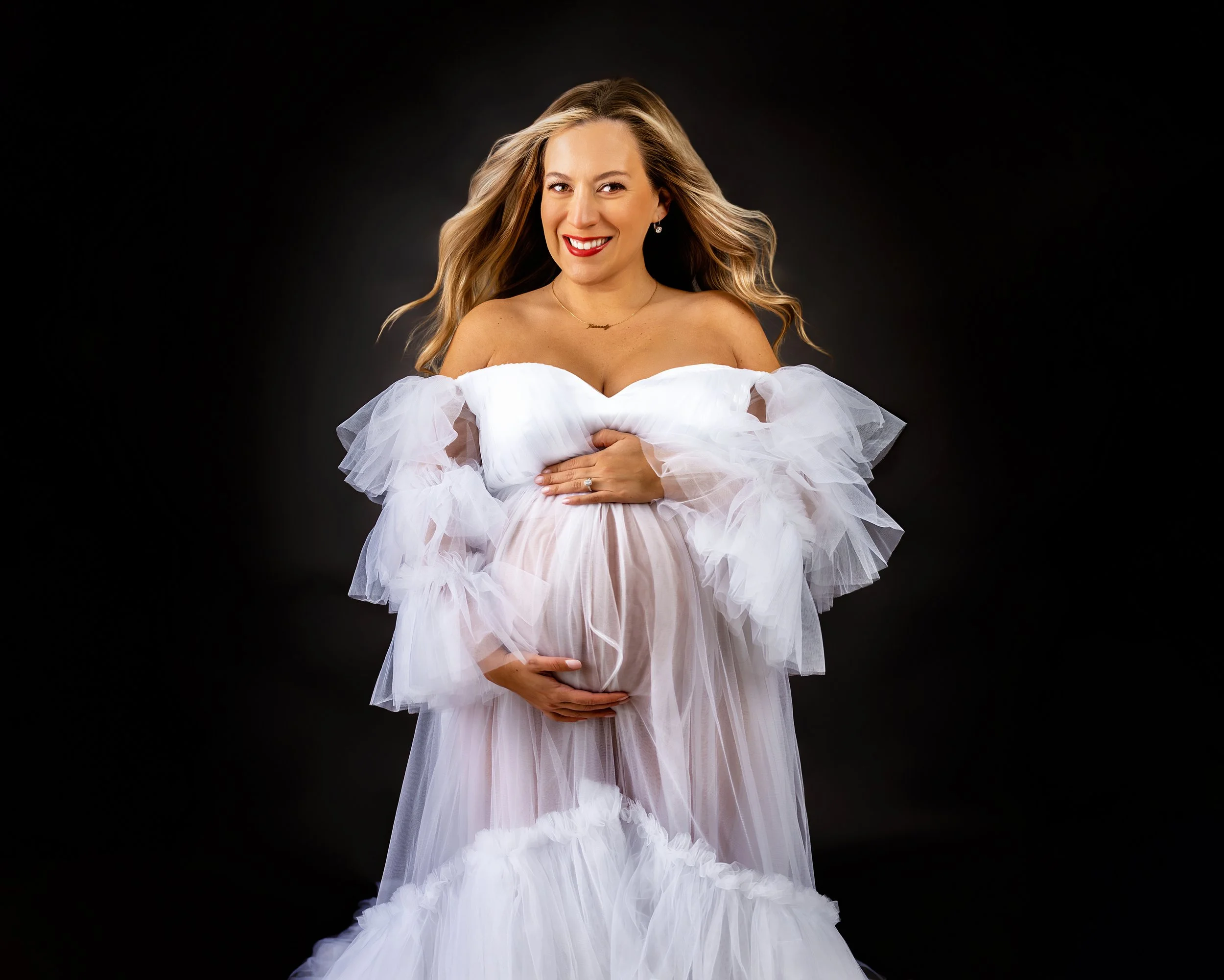 Pregnant Mother in white gown with hair blowing at an In-studio Maternity Photography Session with Two Wild Souls Photography