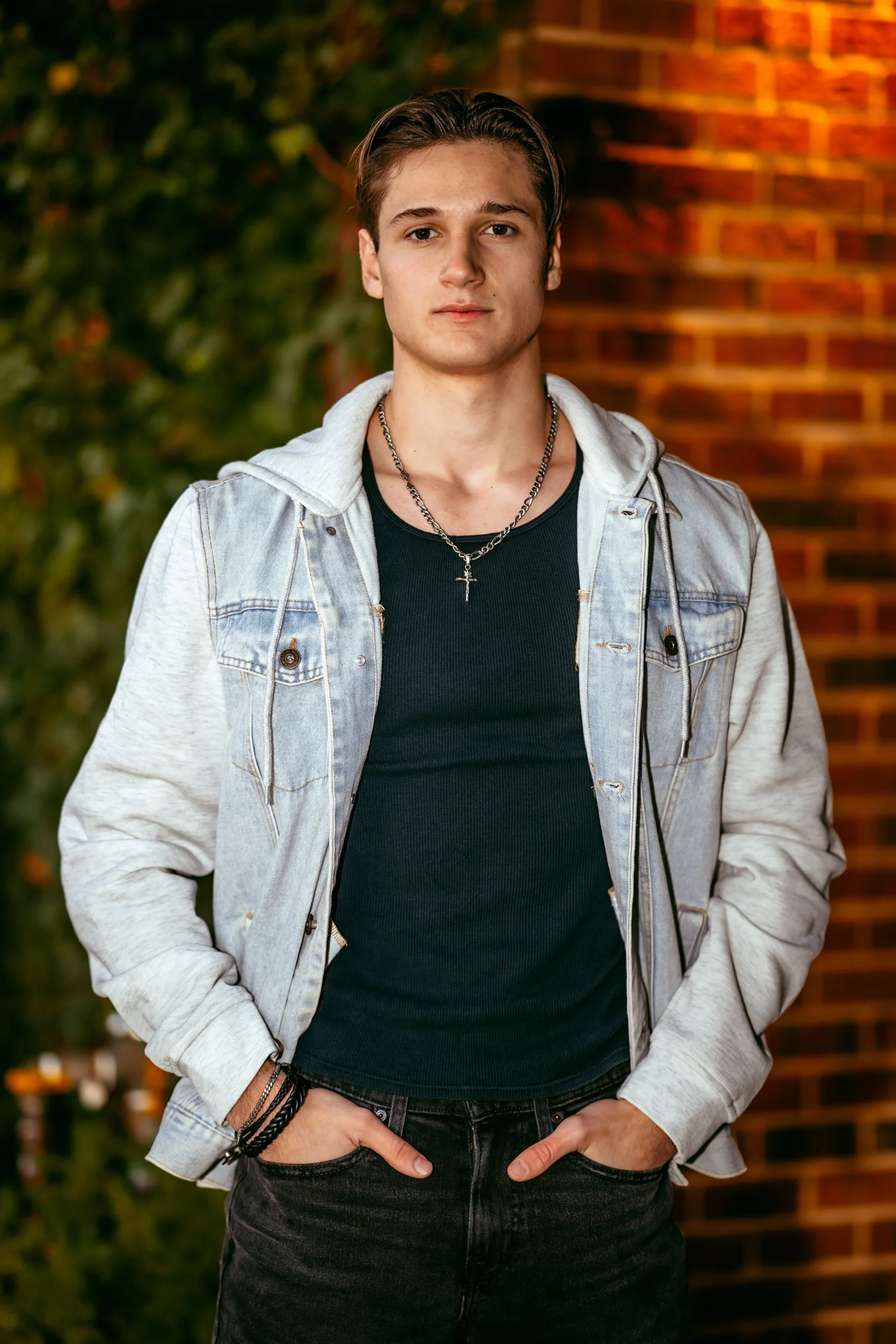 Man posed in front of brick wall at high school senior photography session with Two Wild Souls Photography