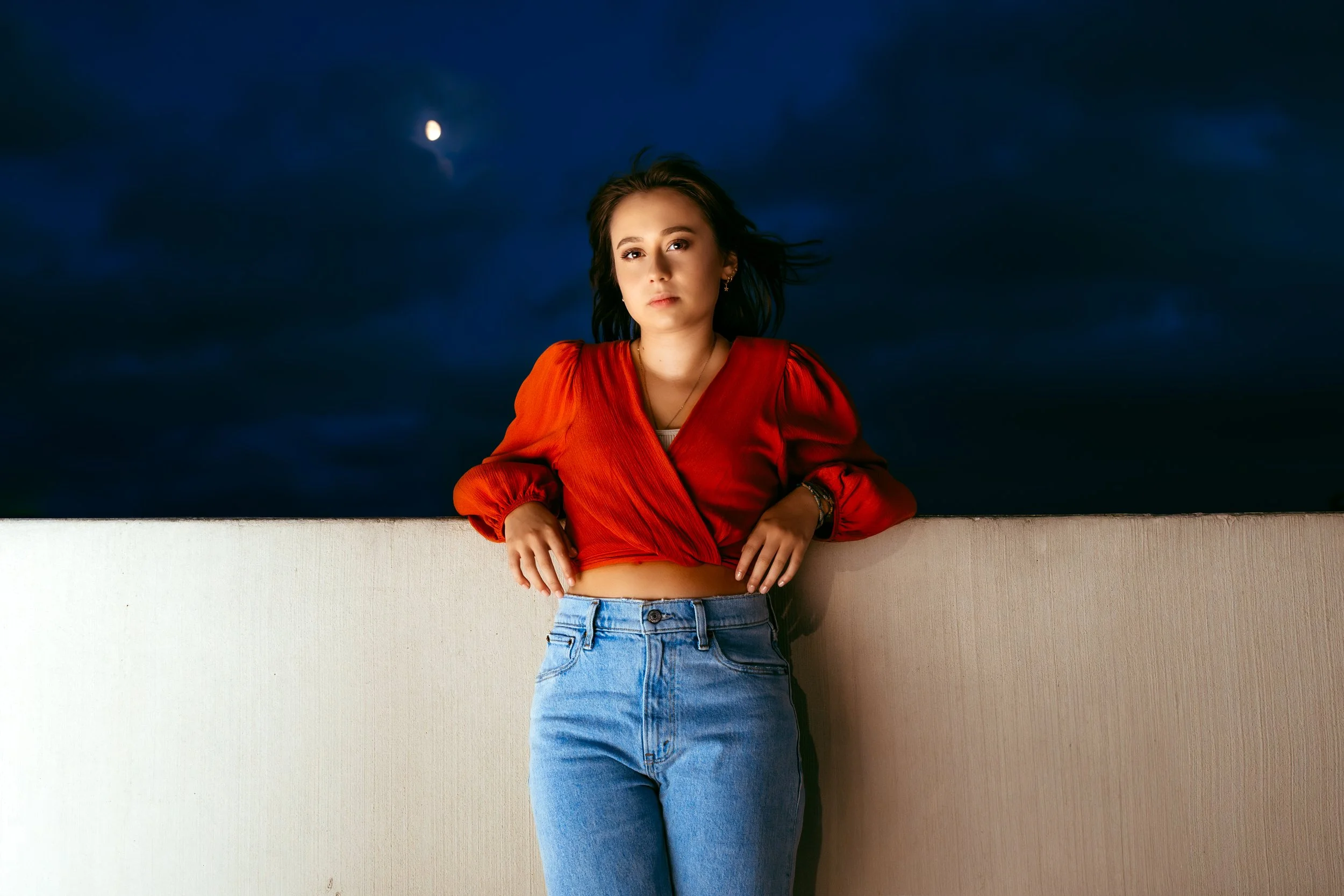 Woman gazing into camera lens at her high school senior photo session with Two Wild Souls Photography