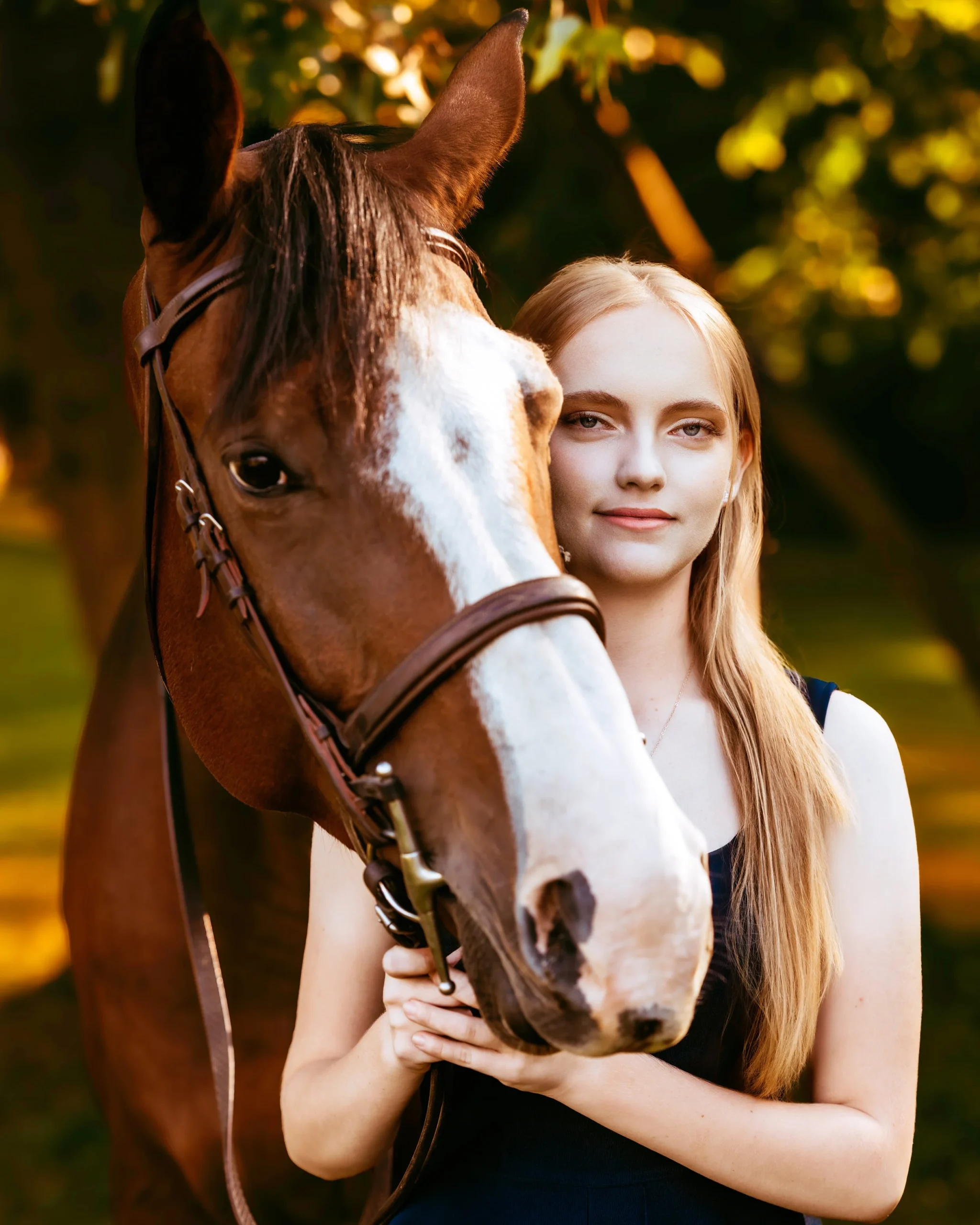 Woman posing with her horse at her high school senior photo session with Two Wild Souls Photography