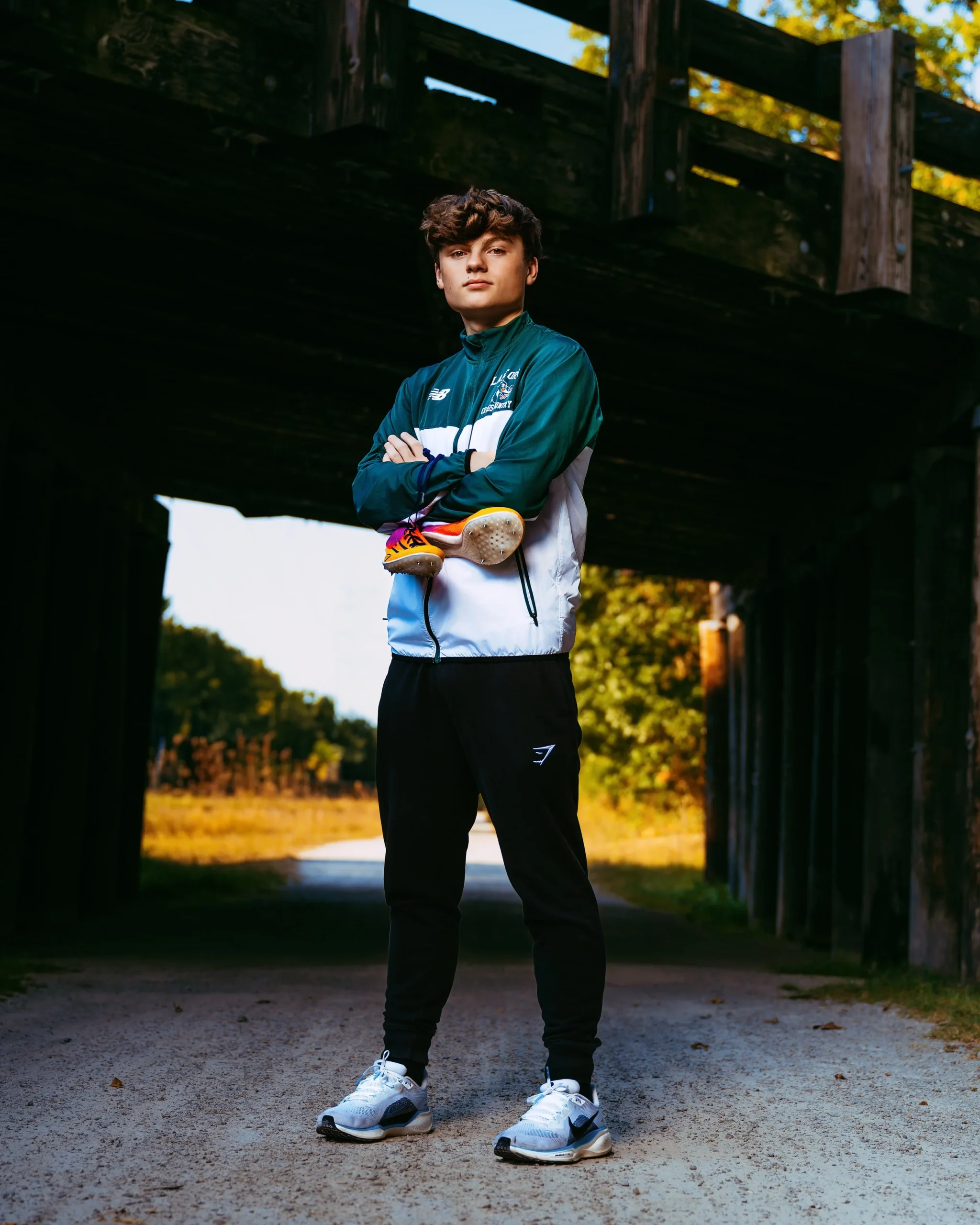 Man posed with running shoes at high school senior photography session with Two Wild Souls Photography
