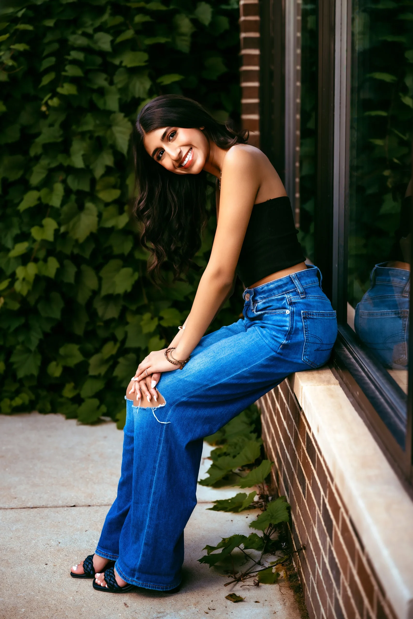 Woman posing in downtown Rochester, Michigan at her high school senior photo session with Two Wild Souls Photography