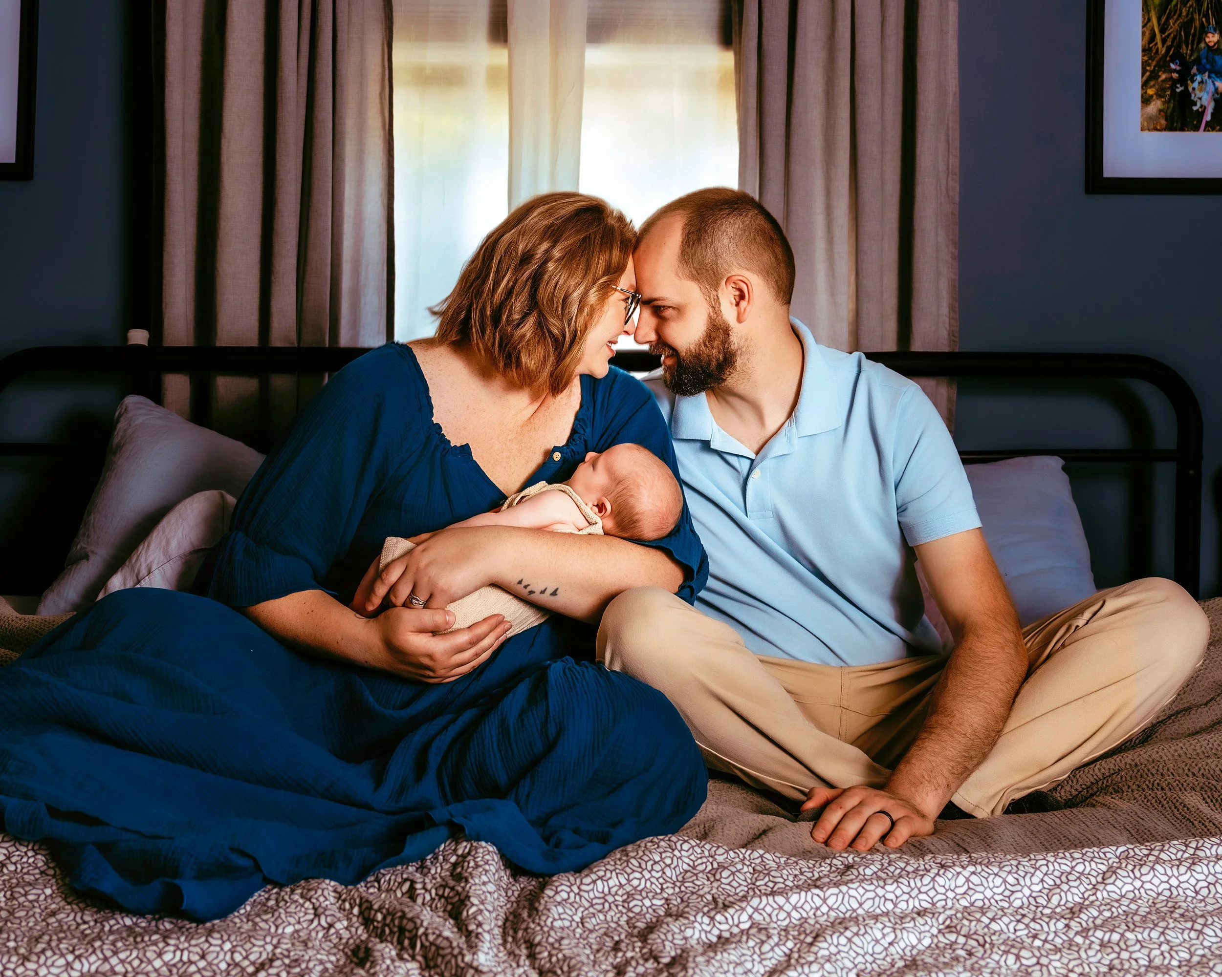 Family of 3 sitting in bed at Newborn Photography Session with Two Wild Souls Photography