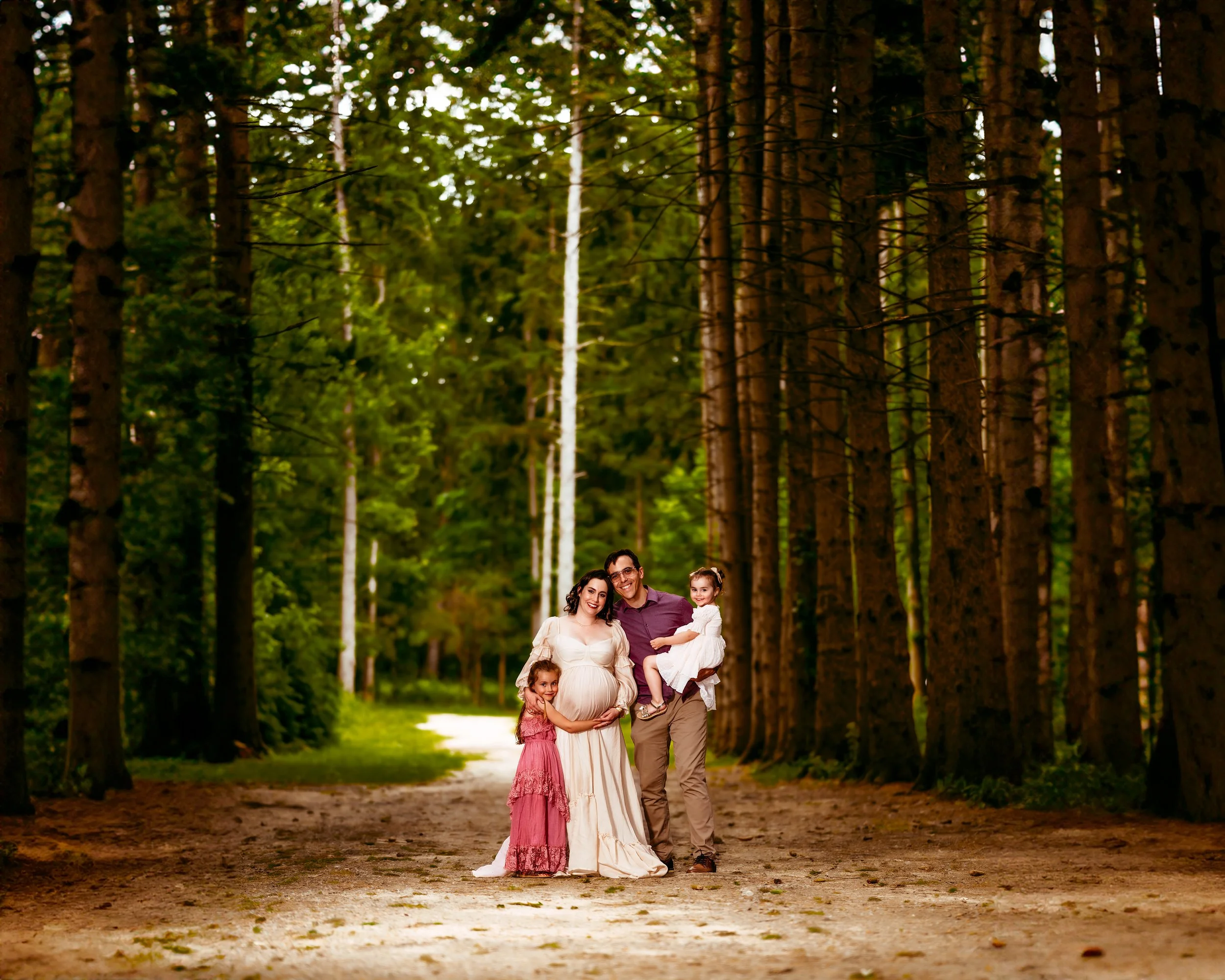 Family with a Pregnant woman in the woods hugging at a Two Wild Souls Photography Session
